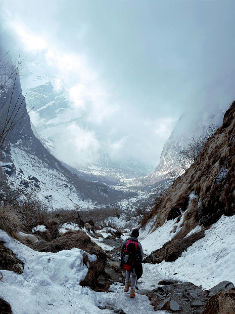 Homme face à une vallée montagneuse enneigée
