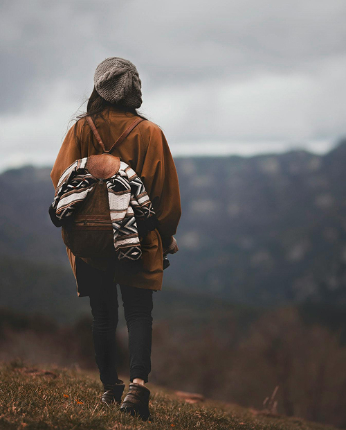 Maxime debout sur des marches pointant le ciel avec ses doigts