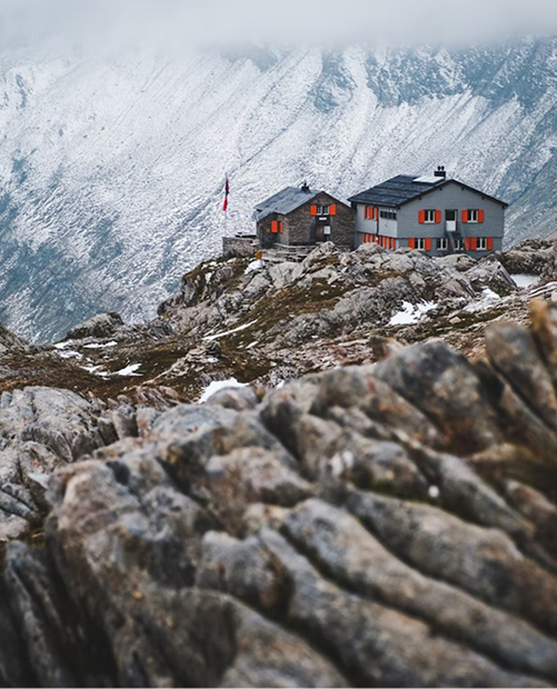Photo extérieure d'un refuge de montagne avec vue sur une vallée enneigée
